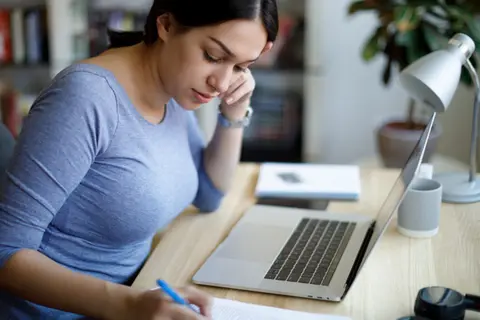 Junge Frau sitzt am Laptop